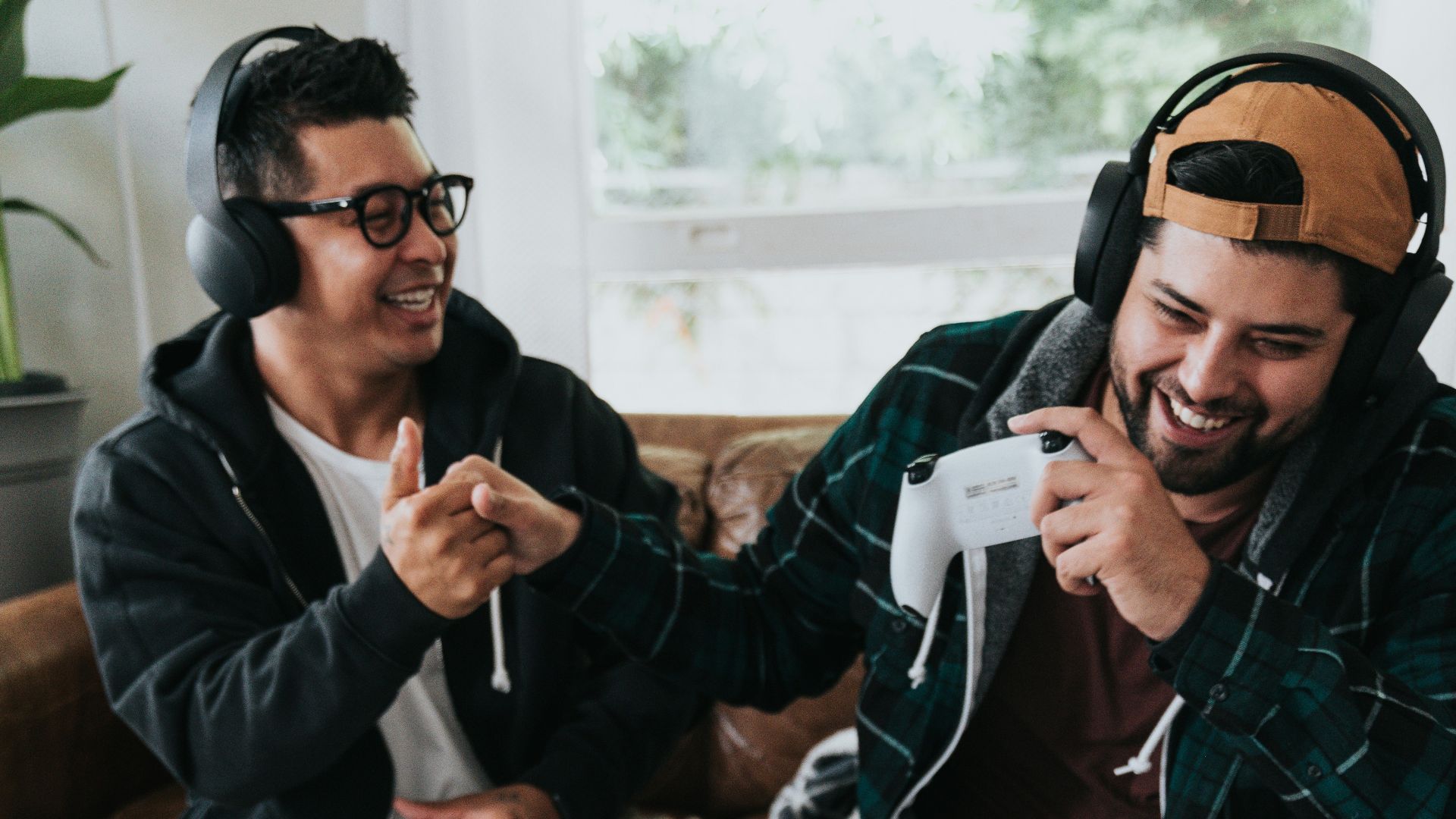 a group of men sitting on a couch and holding game controllers
