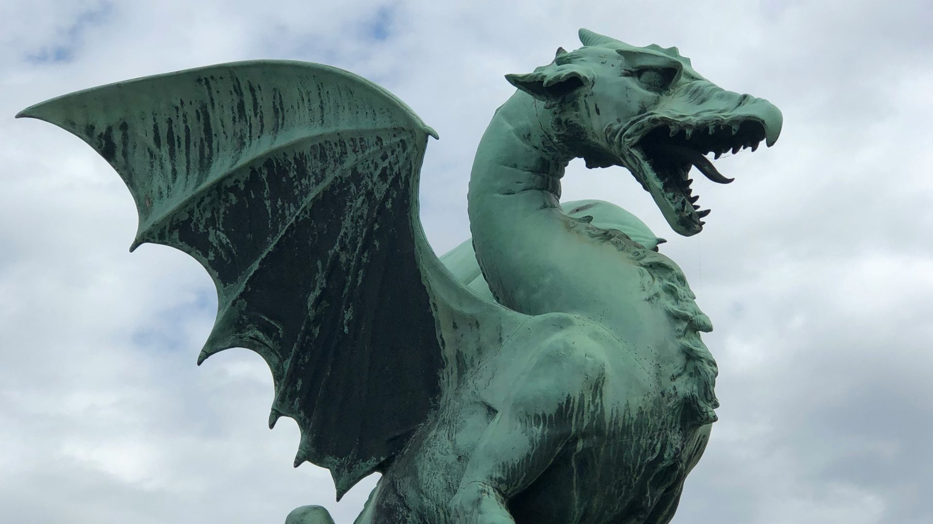 a statue of a green dragon on a pedestal