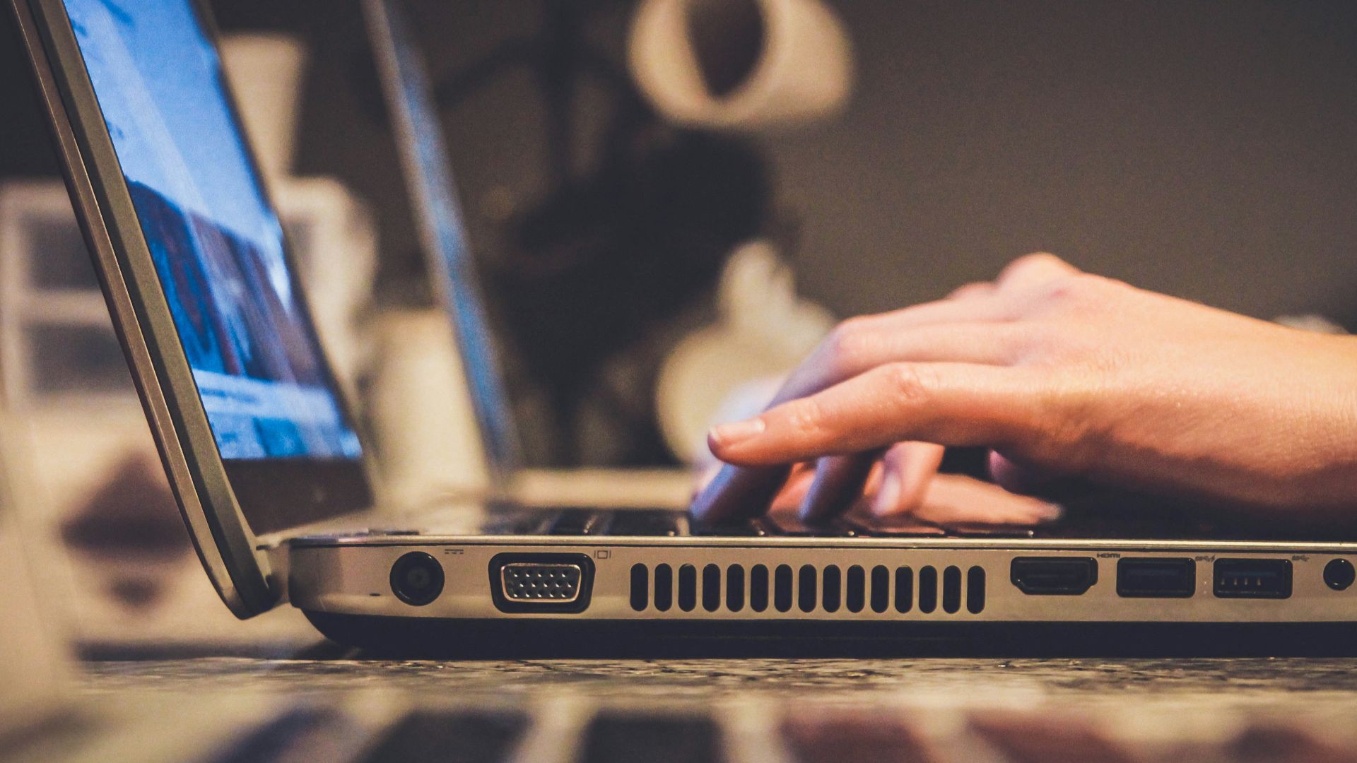 person using silver laptop computer on desk