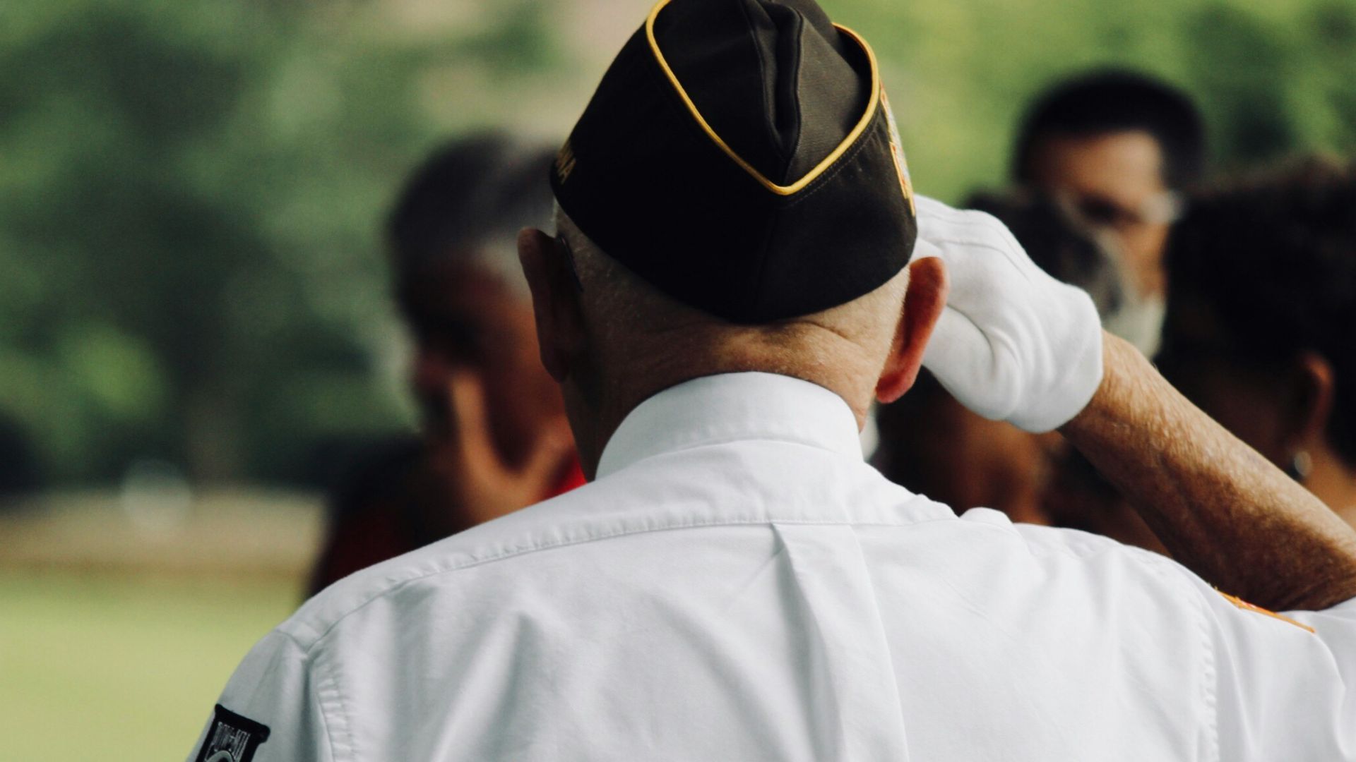 man wearing white uniform saluting