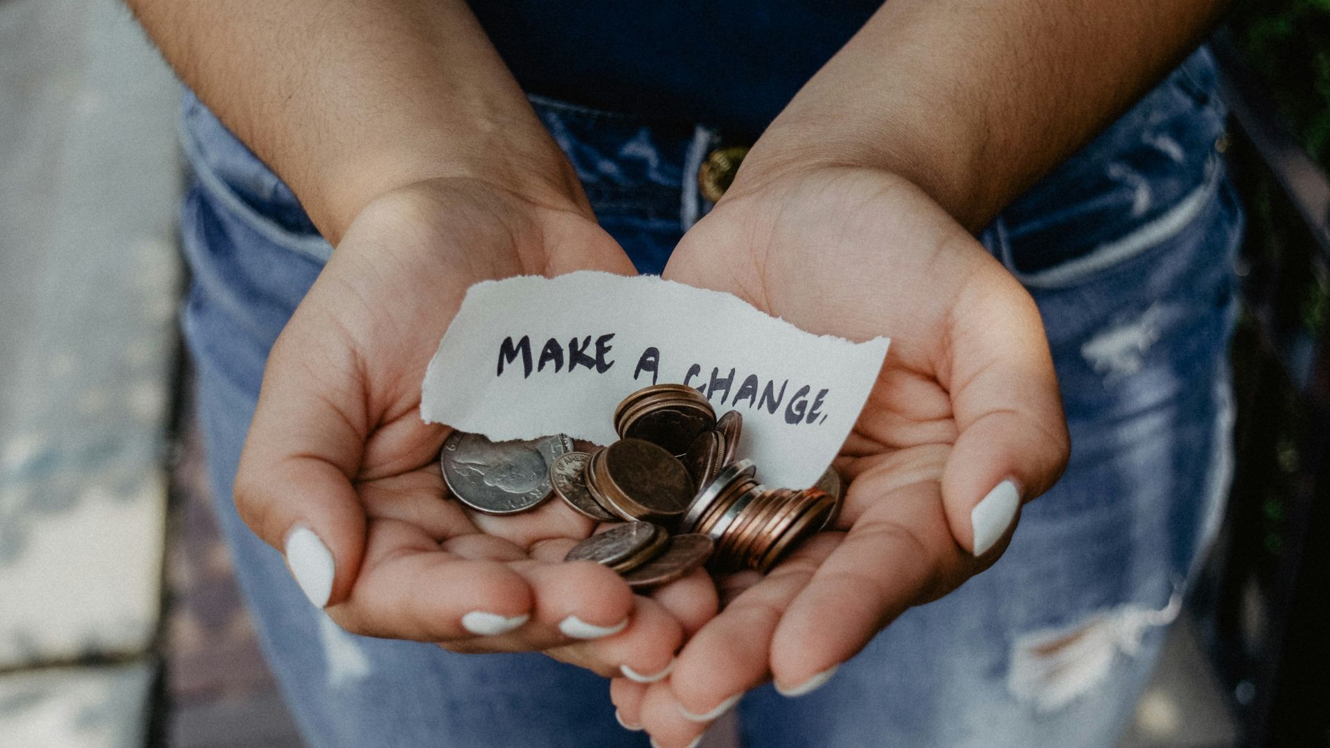 person showing both hands with make a change note and coins