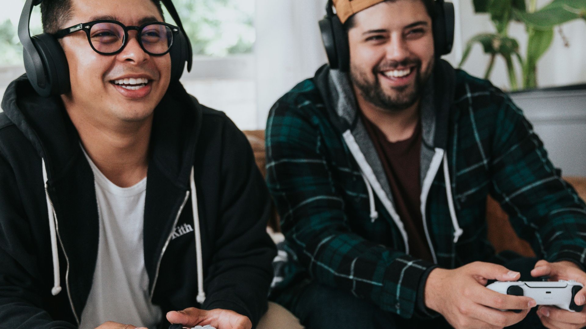 a couple of men sitting at a table with game controllers