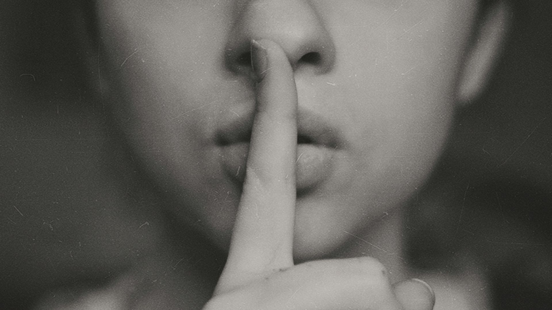 grayscale photo of woman doing silent hand sign