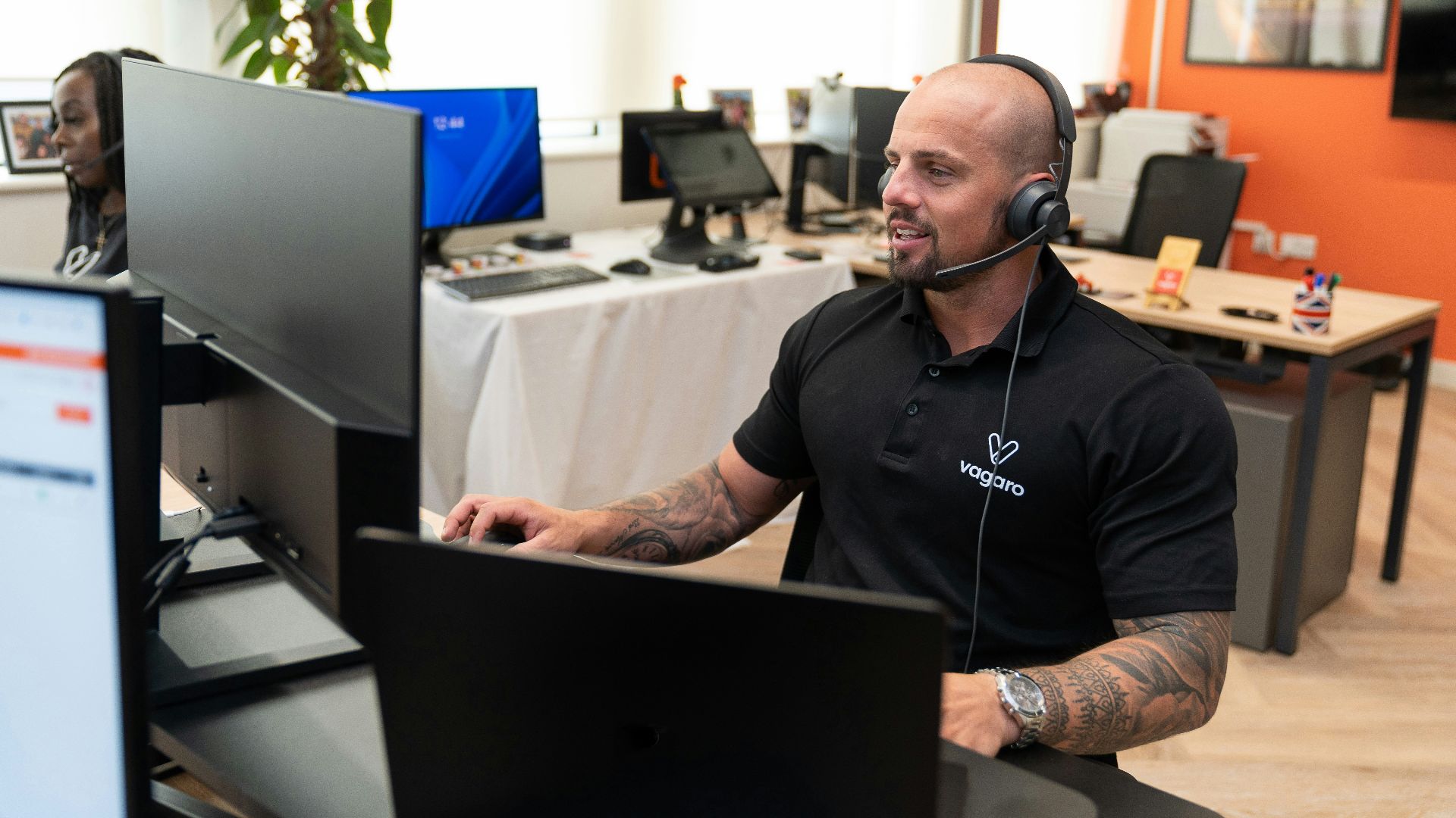 a man wearing a headset sitting in front of a computer