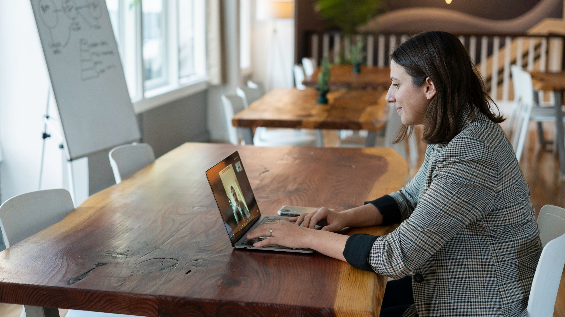 woman in gray and white striped long sleeve shirt using silver macbook