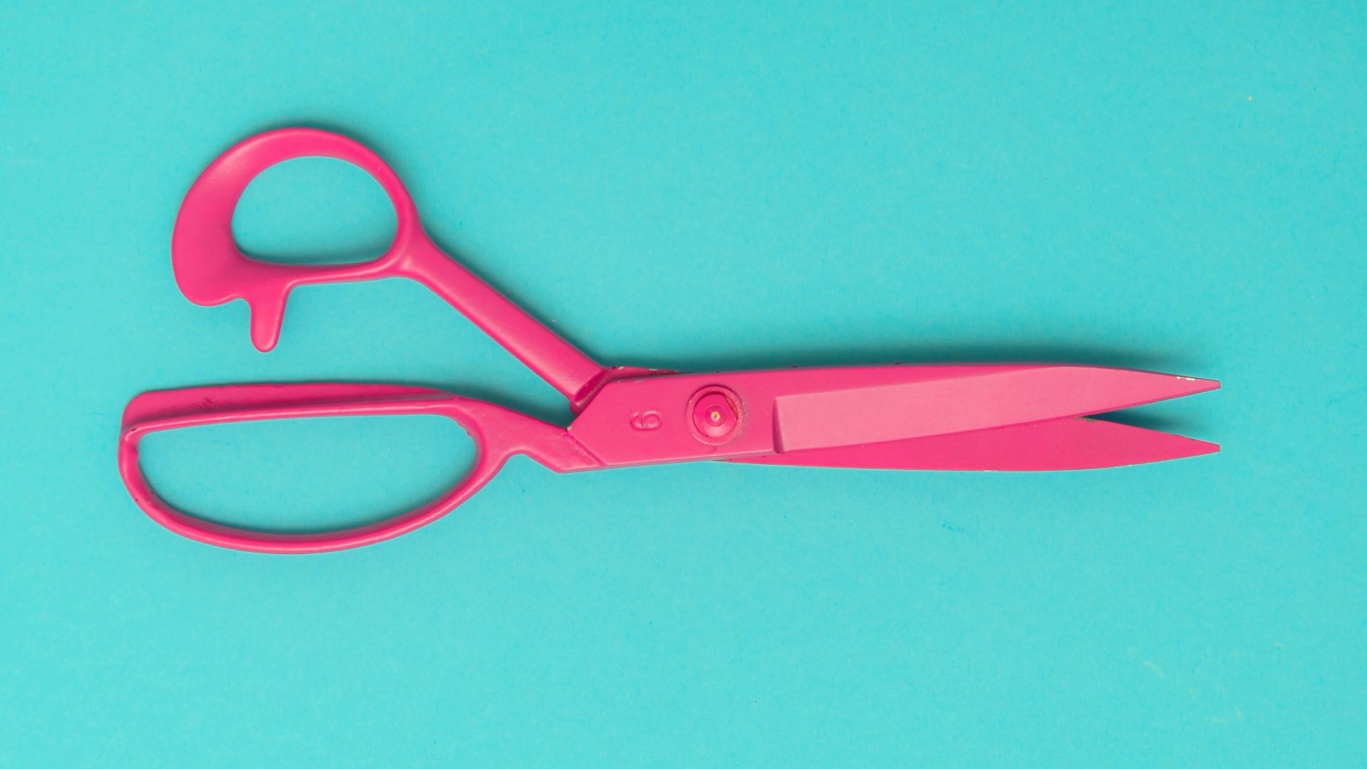 red handled scissors on blue surface