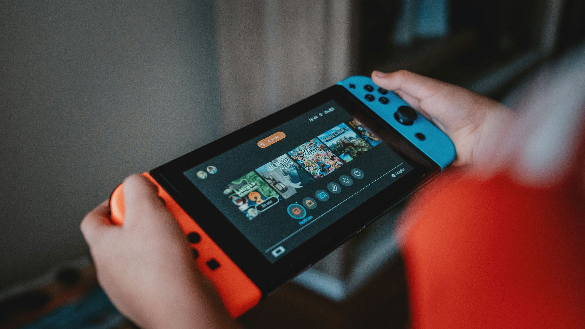 person holding black and orange nintendo switch
