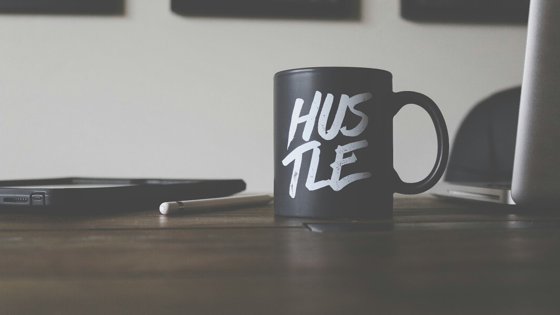 black and white Hustle-printed ceramic mug on table