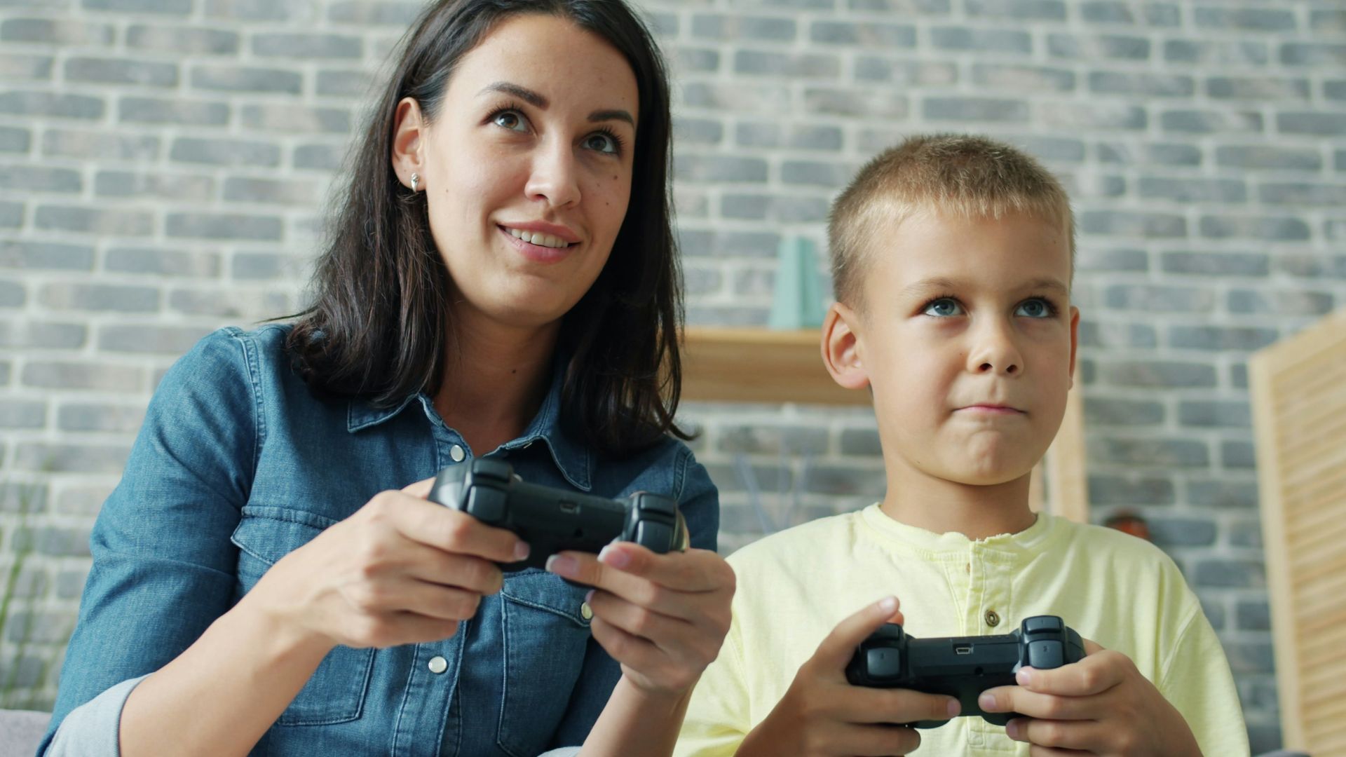 Mother and son playing video games together
