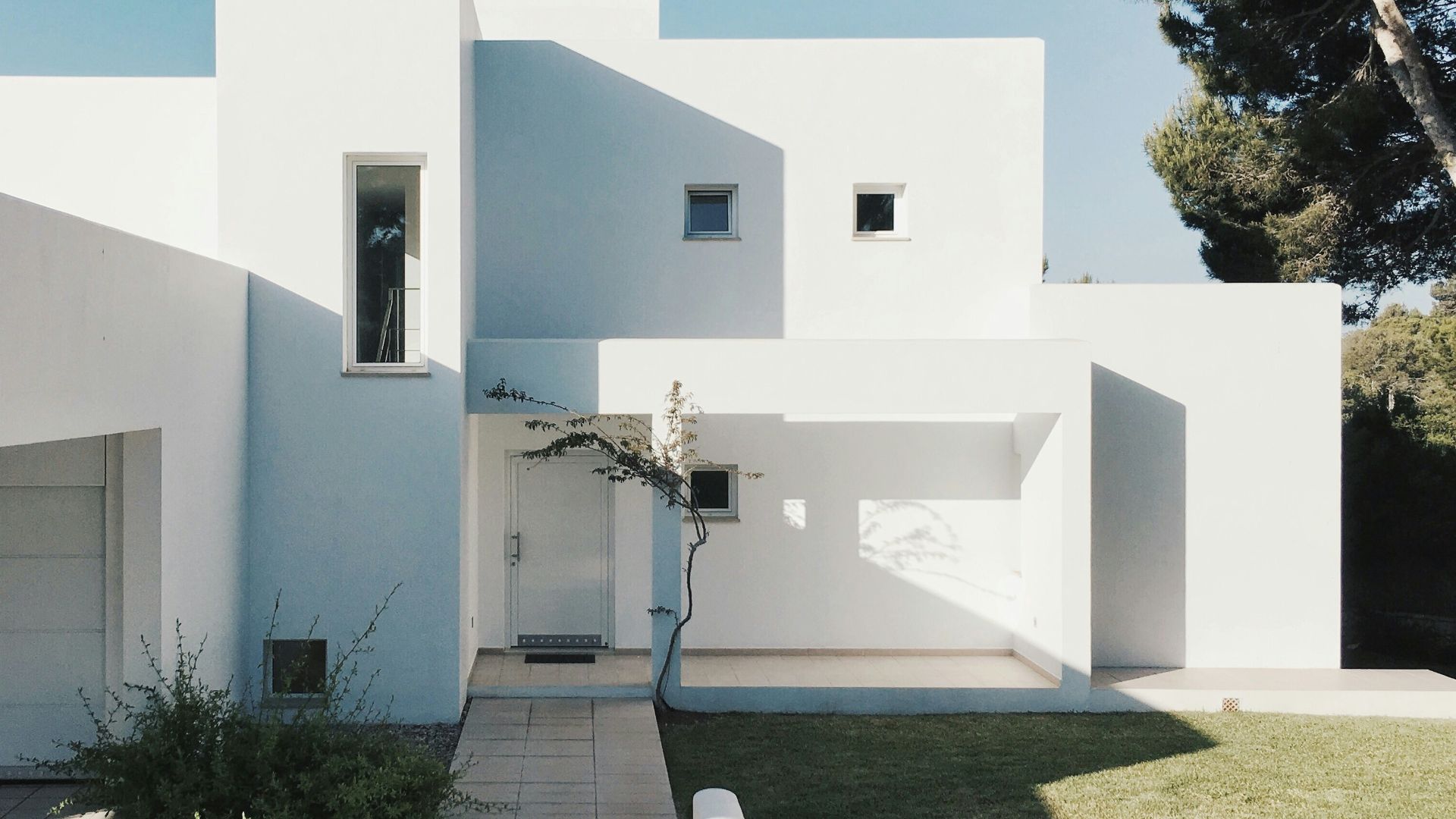 white concrete house near green tree during daytime