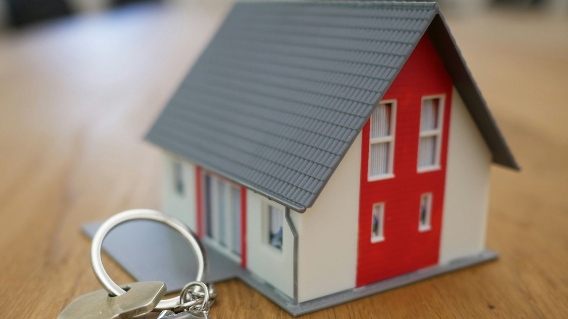 white and red wooden house miniature on brown table