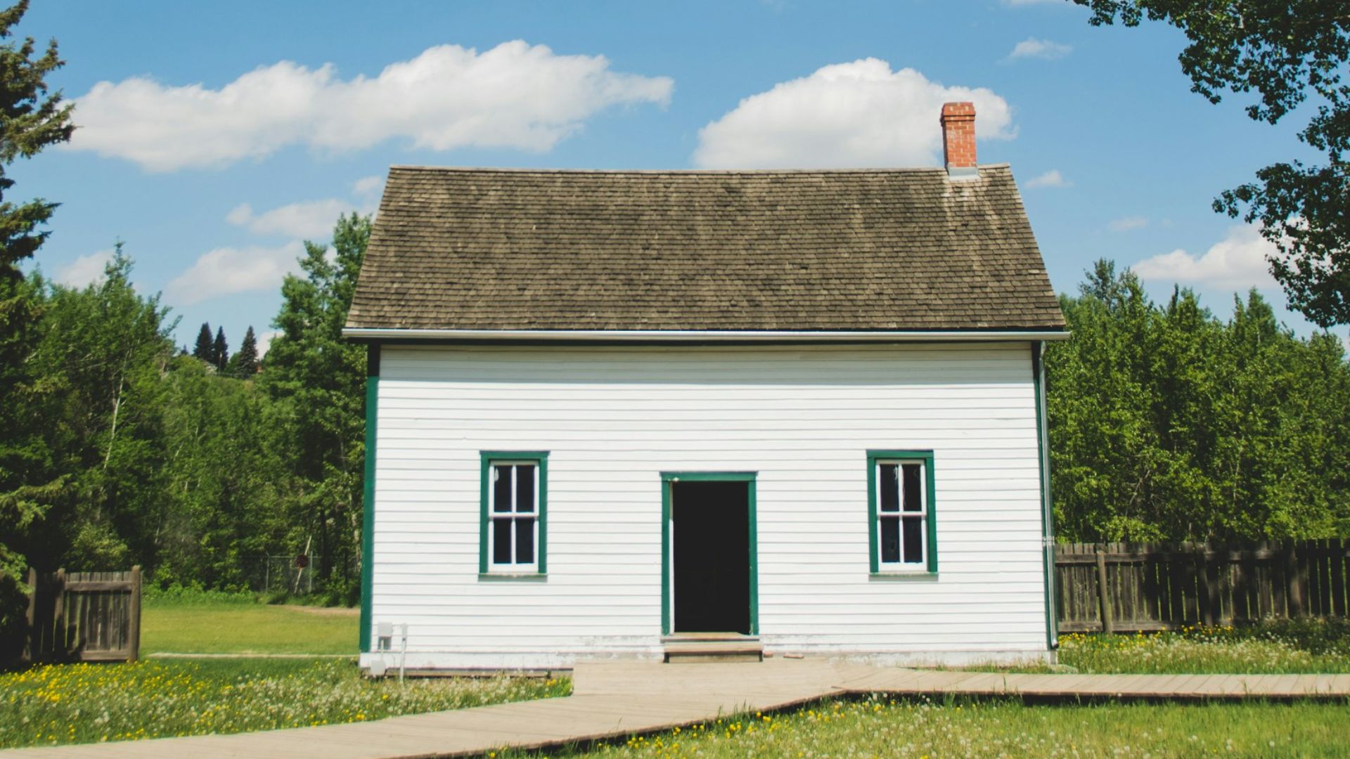 white wooden house between trees