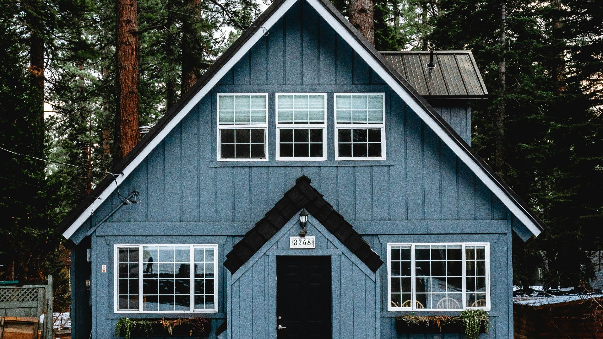 white and brown wooden house near green trees during daytime