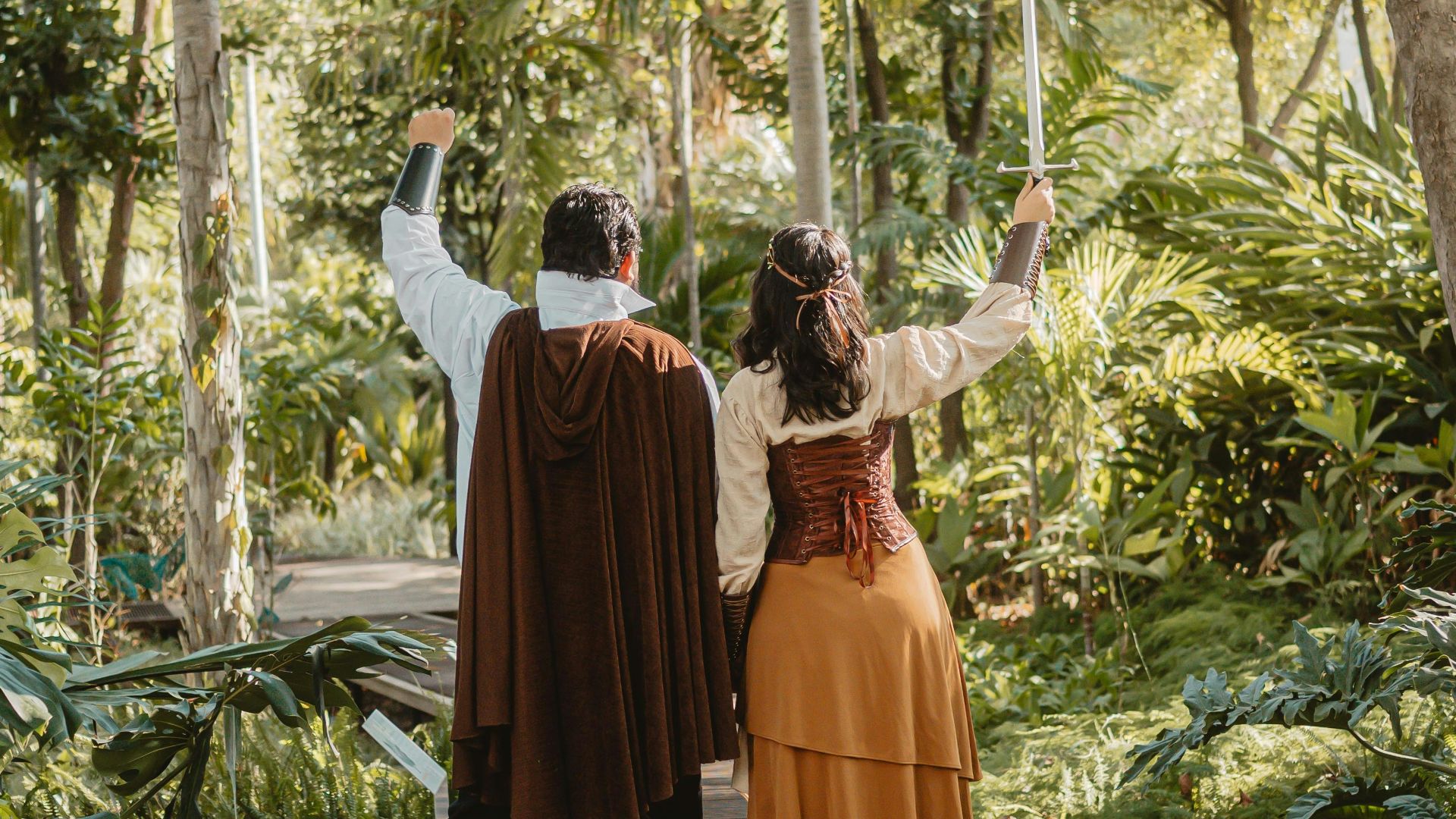 Couple in costumes walking on a wooden path