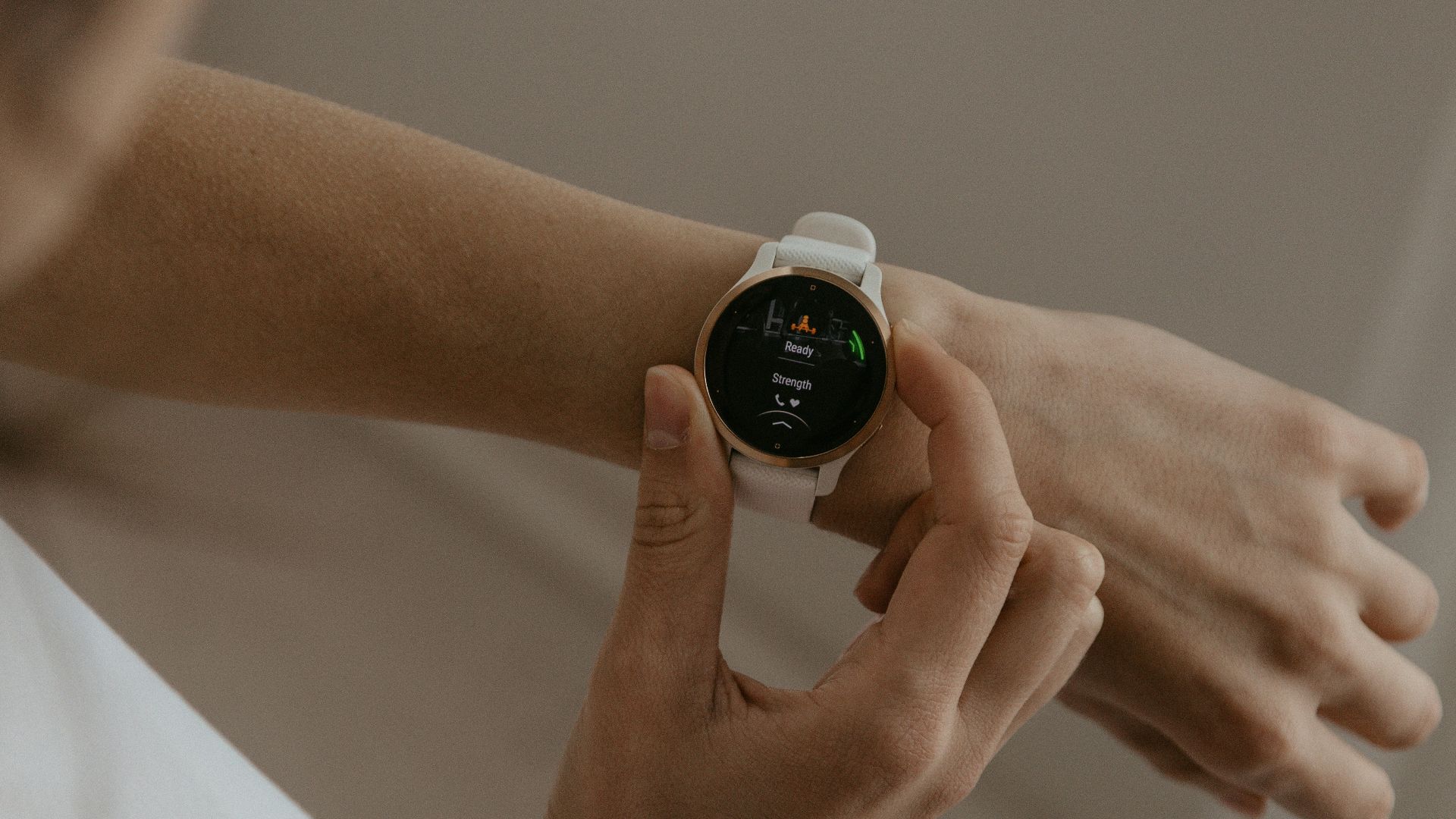 A woman holding a smart watch in her hand