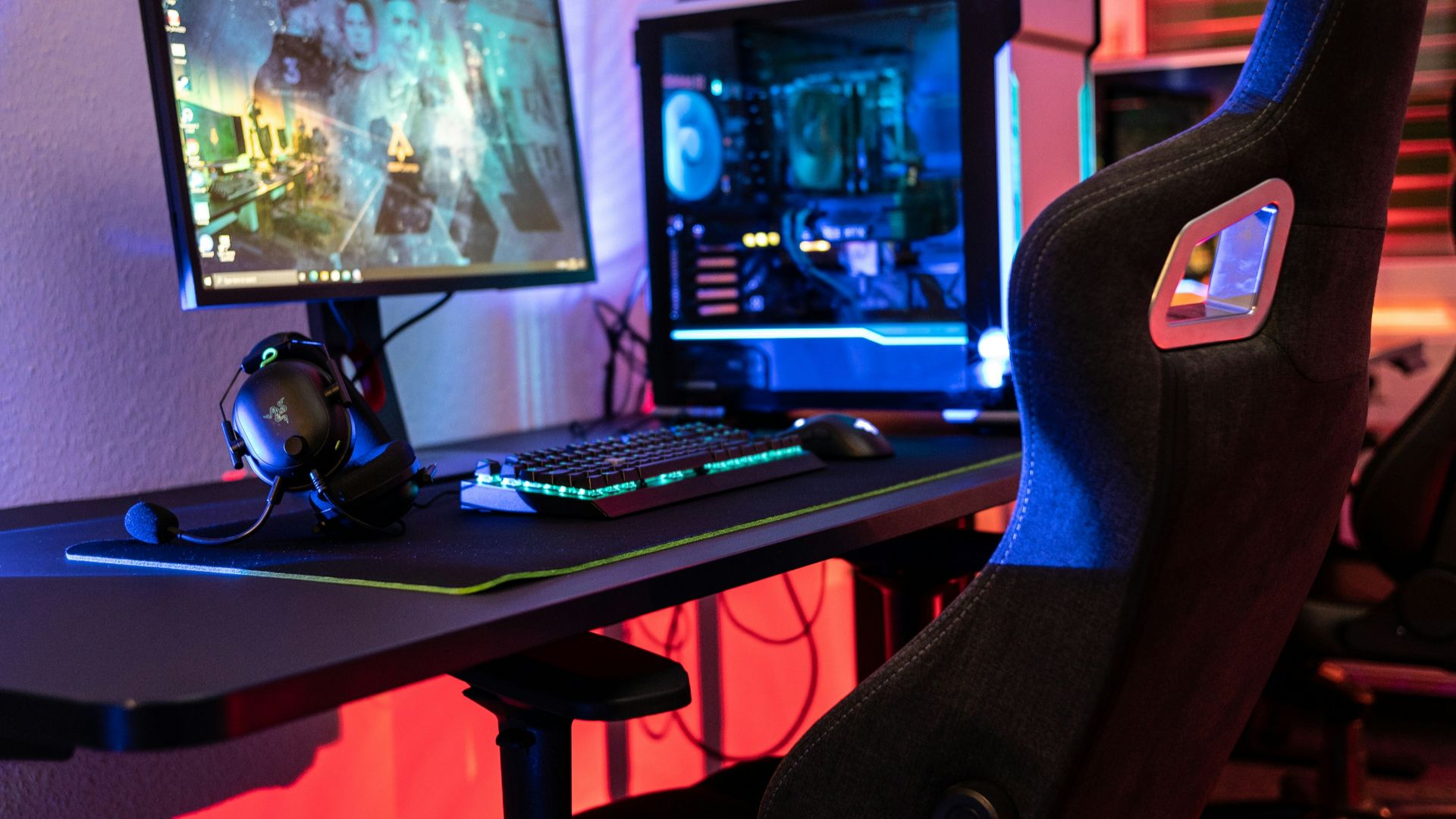 a desk with a computer and a gaming chair