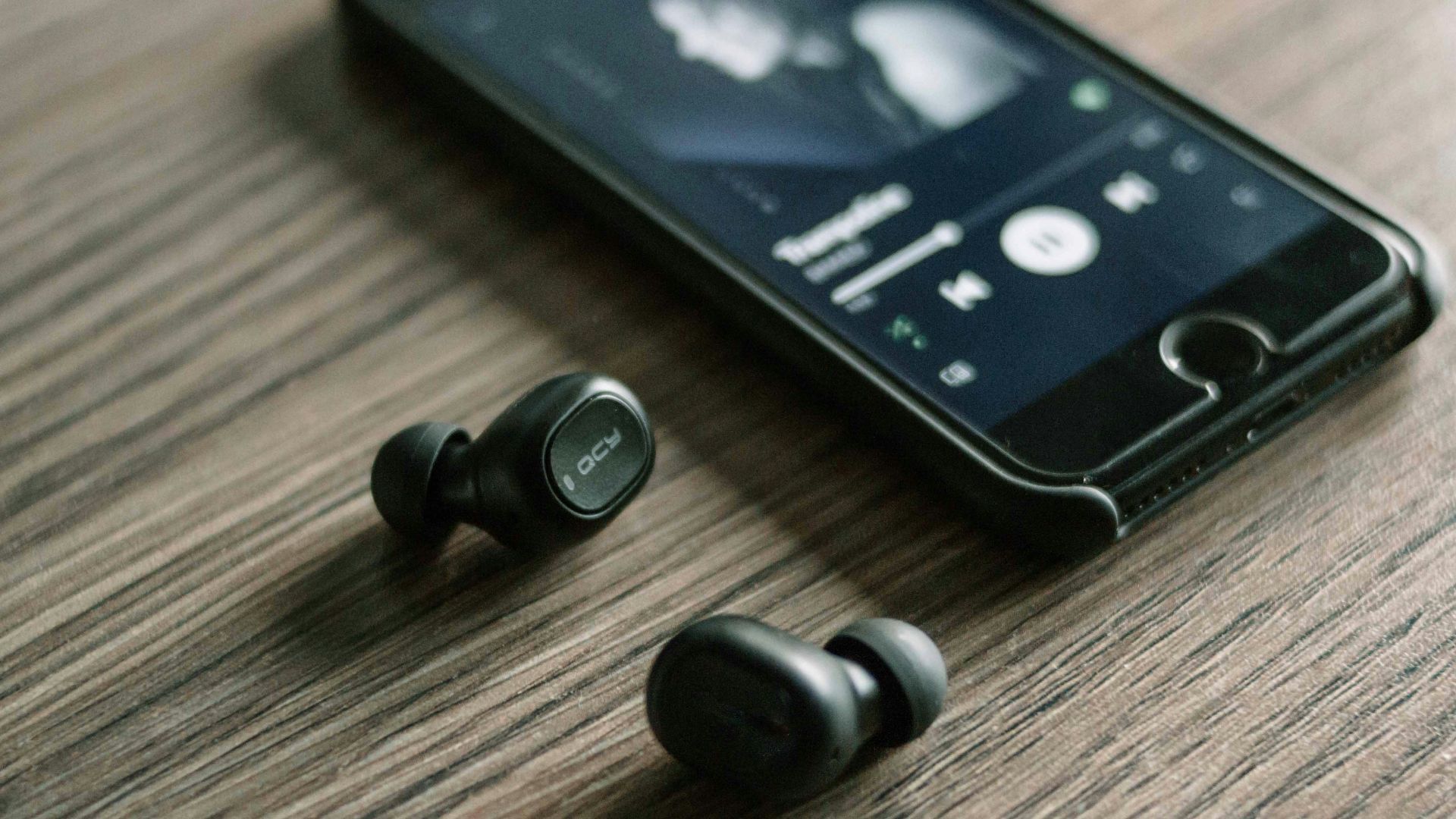 pair of Bluetooth earphones beside phone