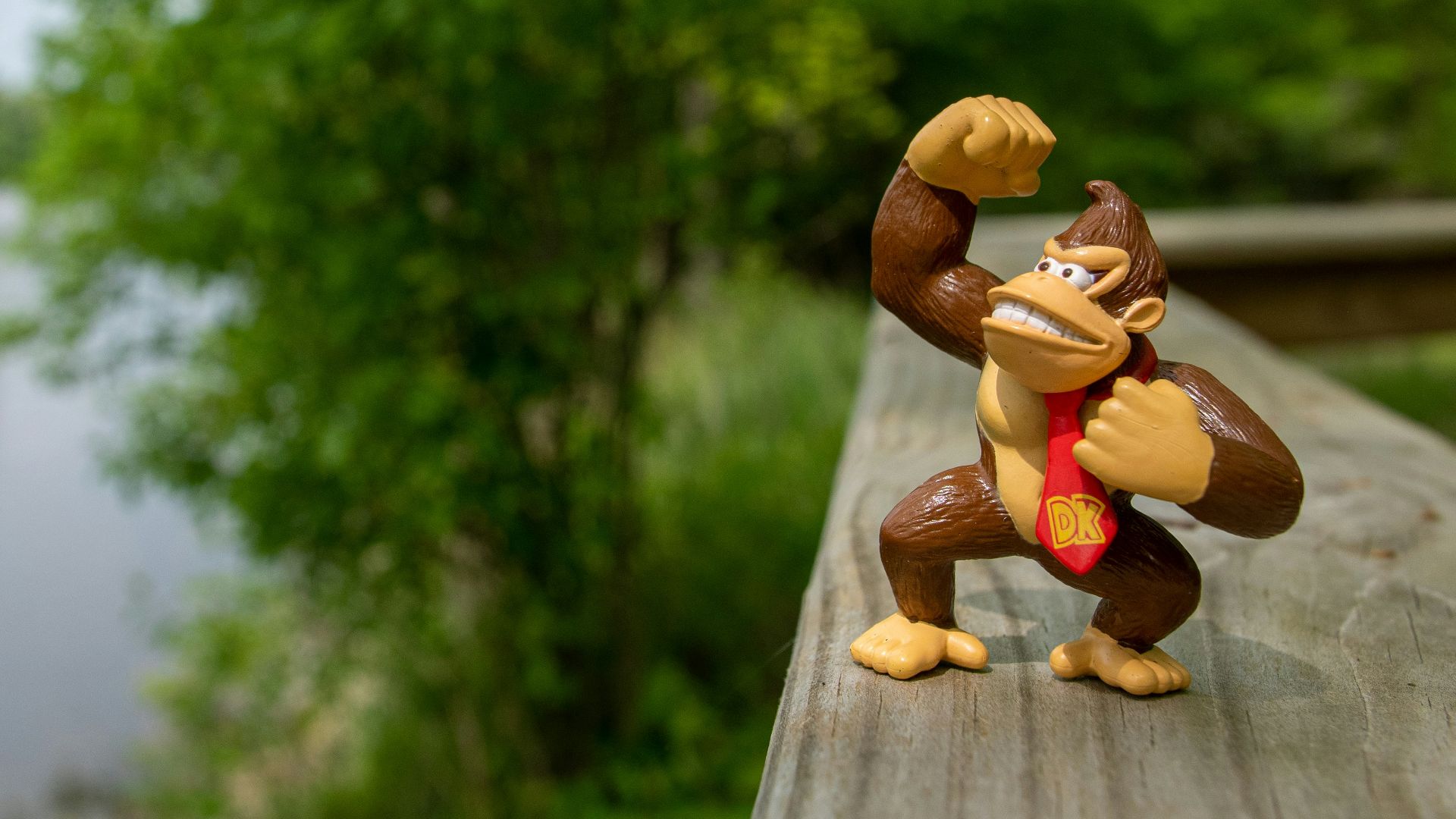 a monkey figurine is posed on a wooden deck