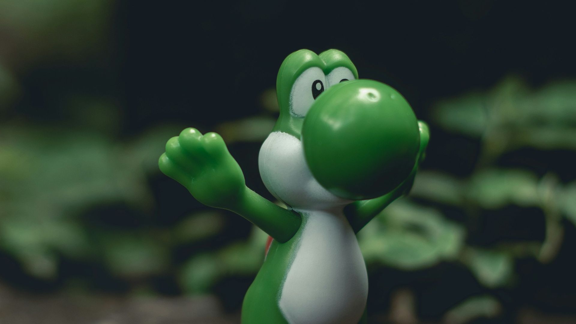 green frog figurine on black and brown surface