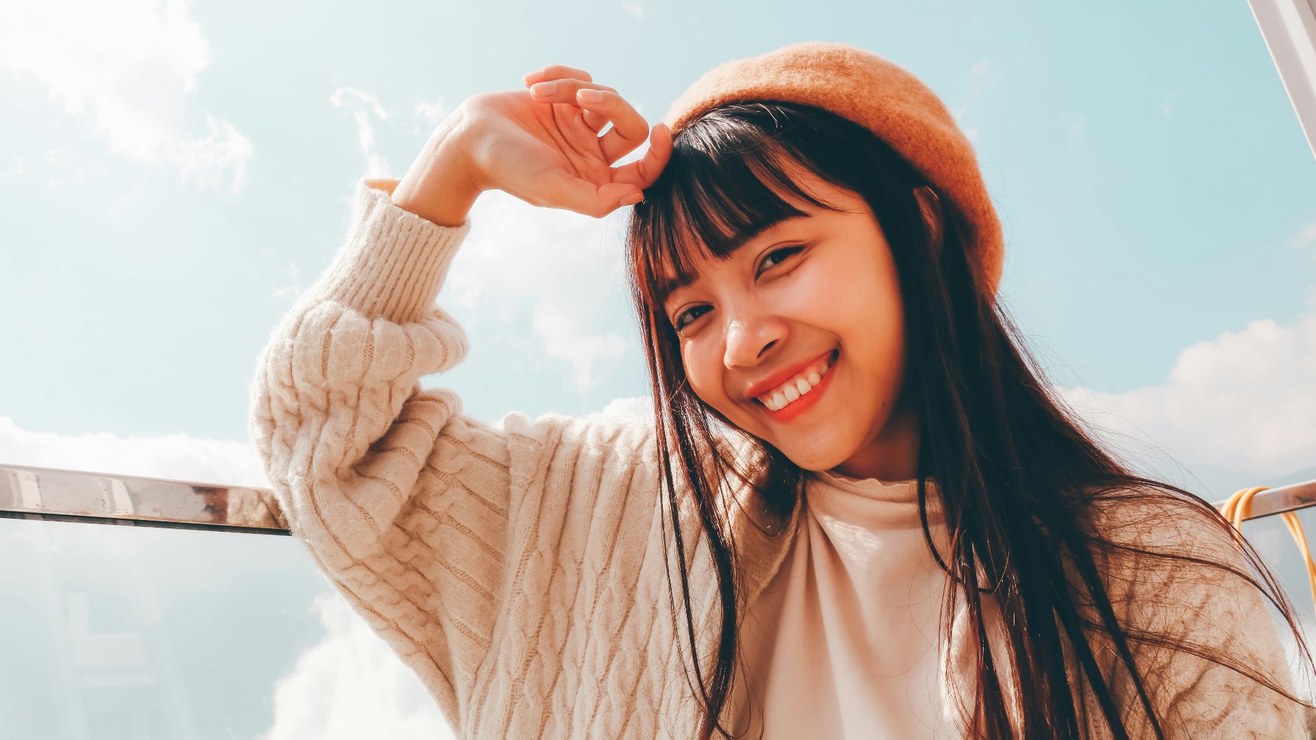 woman in white long sleeve shirt and orange knit cap