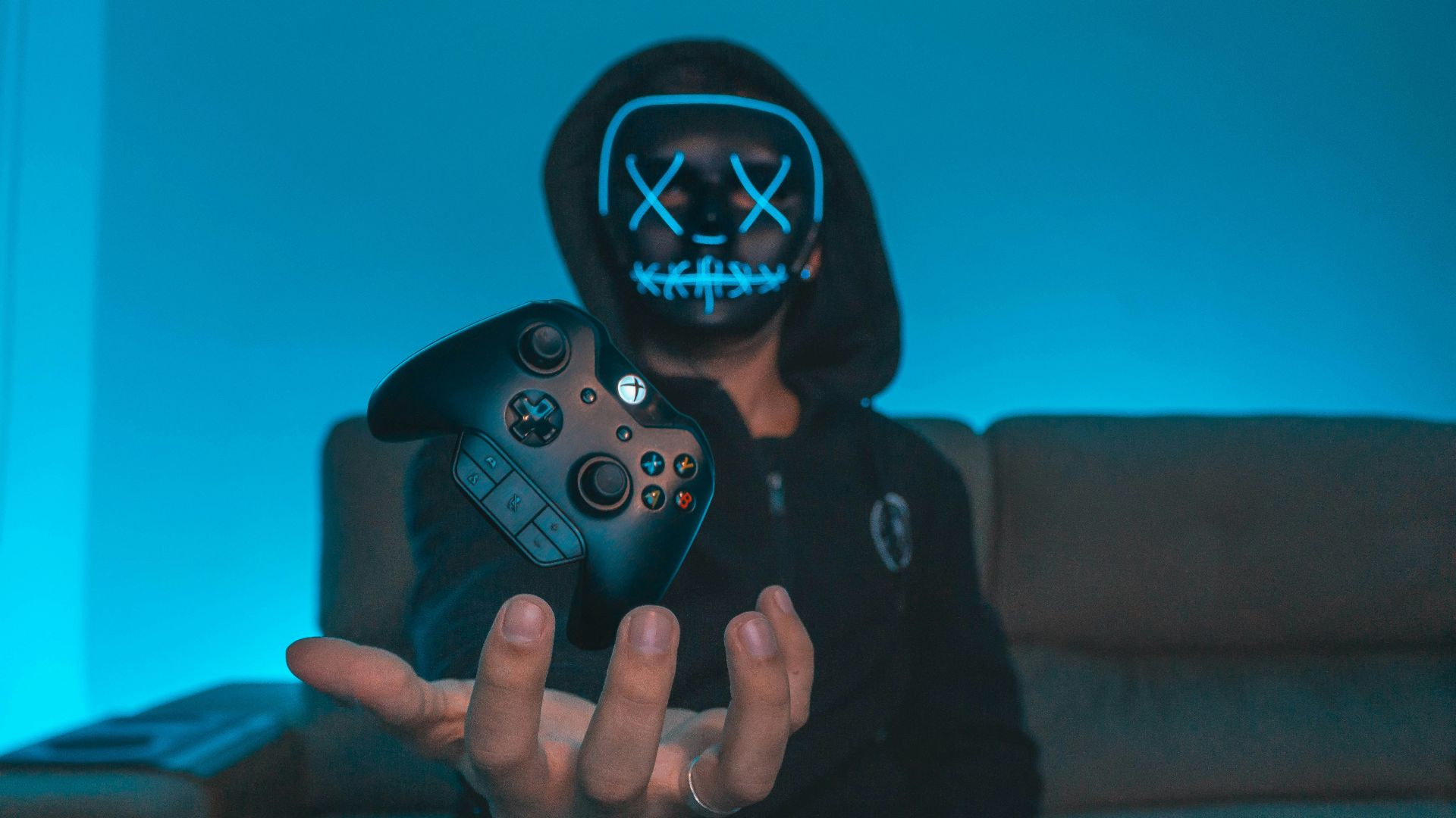 person sitting on chair while holding Xbox One controller