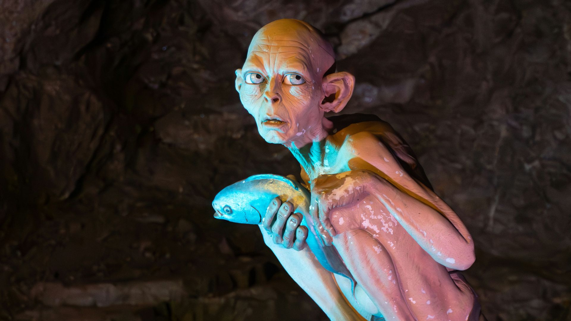 a statue of a man holding a banana in a cave