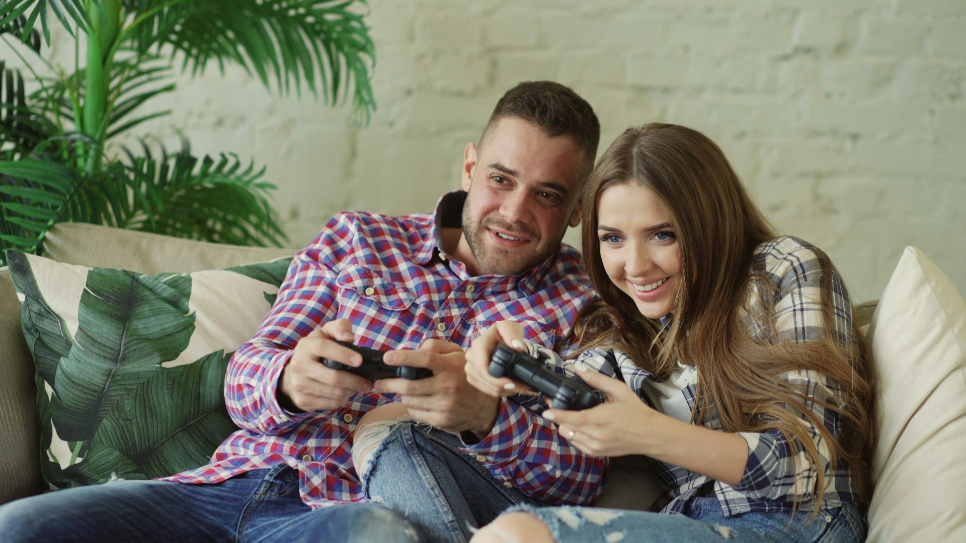 Couple playing video games on couch