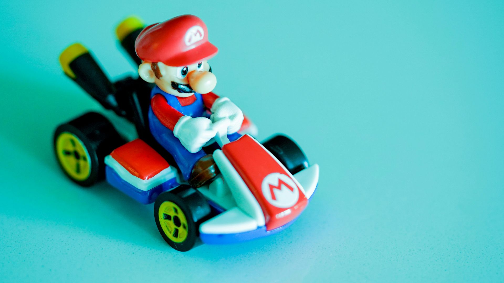 red haired man riding red and blue car plastic toy