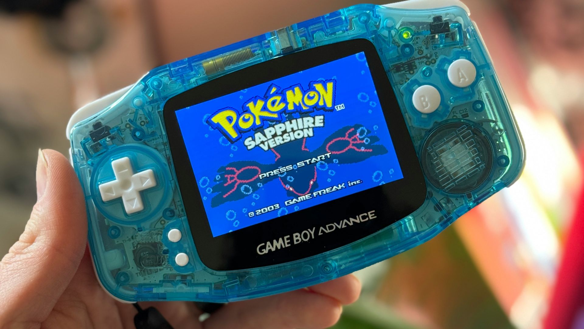 a person holding a gameboy in their hand