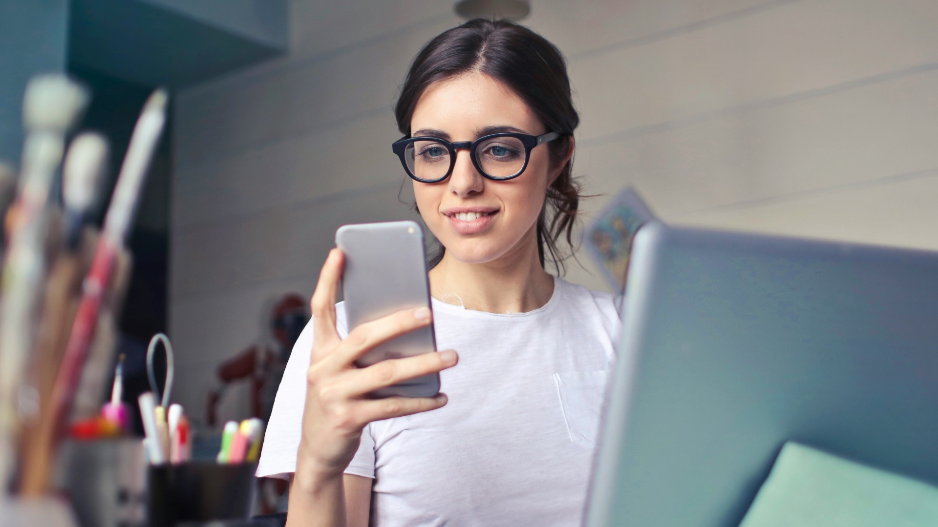woman in white shirt using smartphone