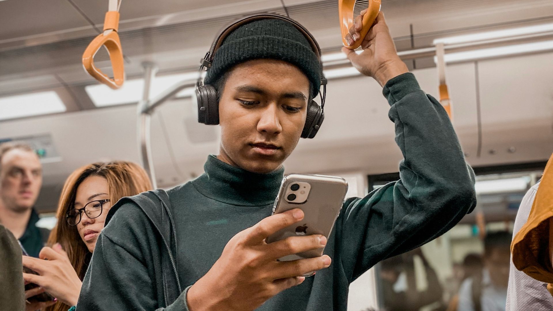 man in train holding smartphone
