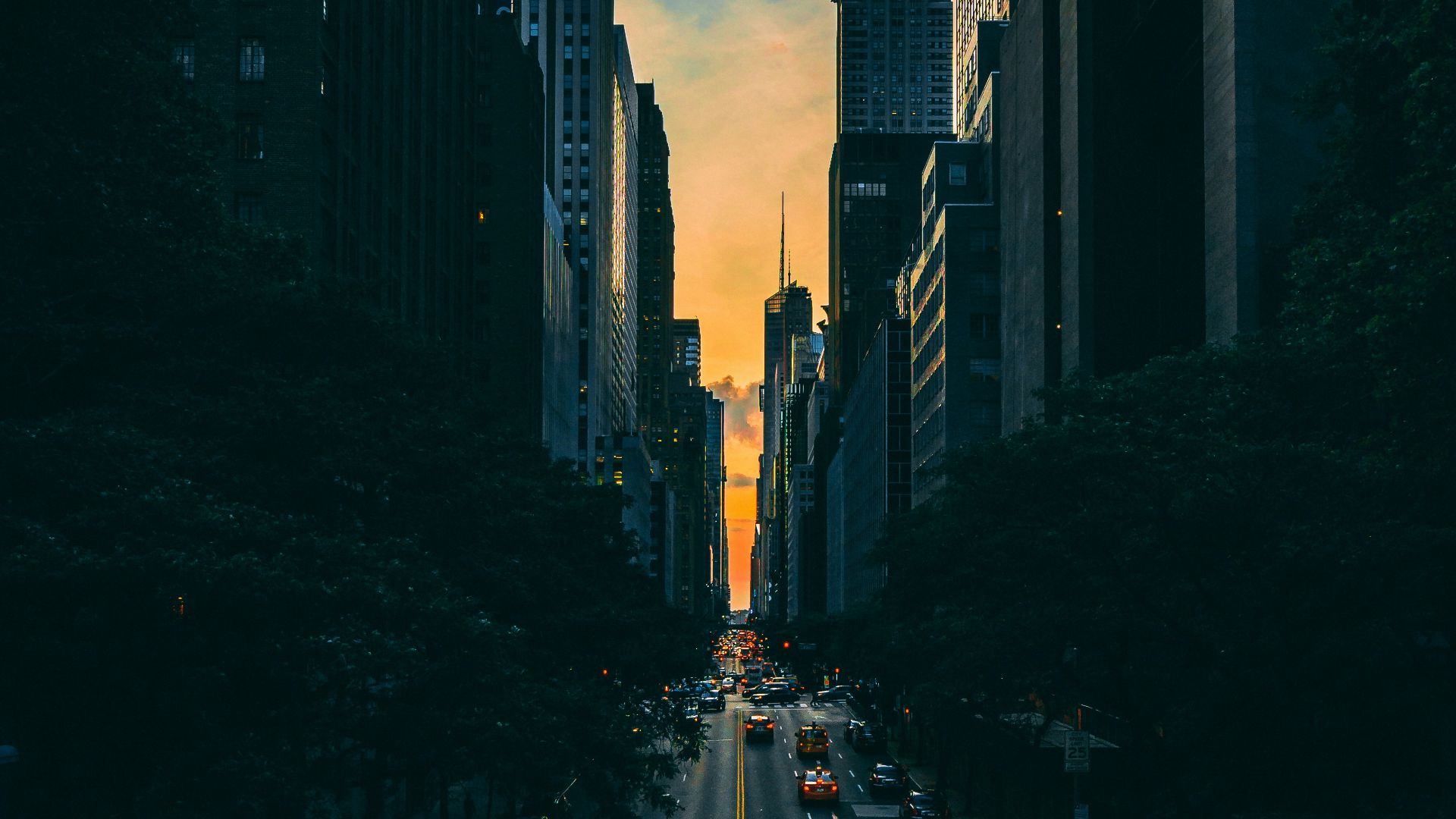 low light photography of vehicle crossing road between high-rise buildings