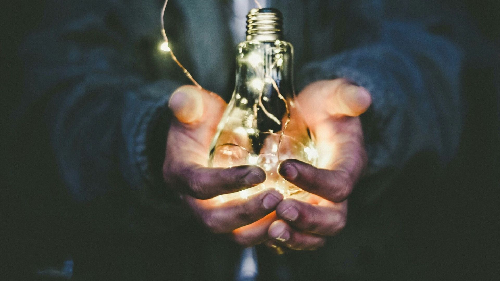 man holding incandescent bulb