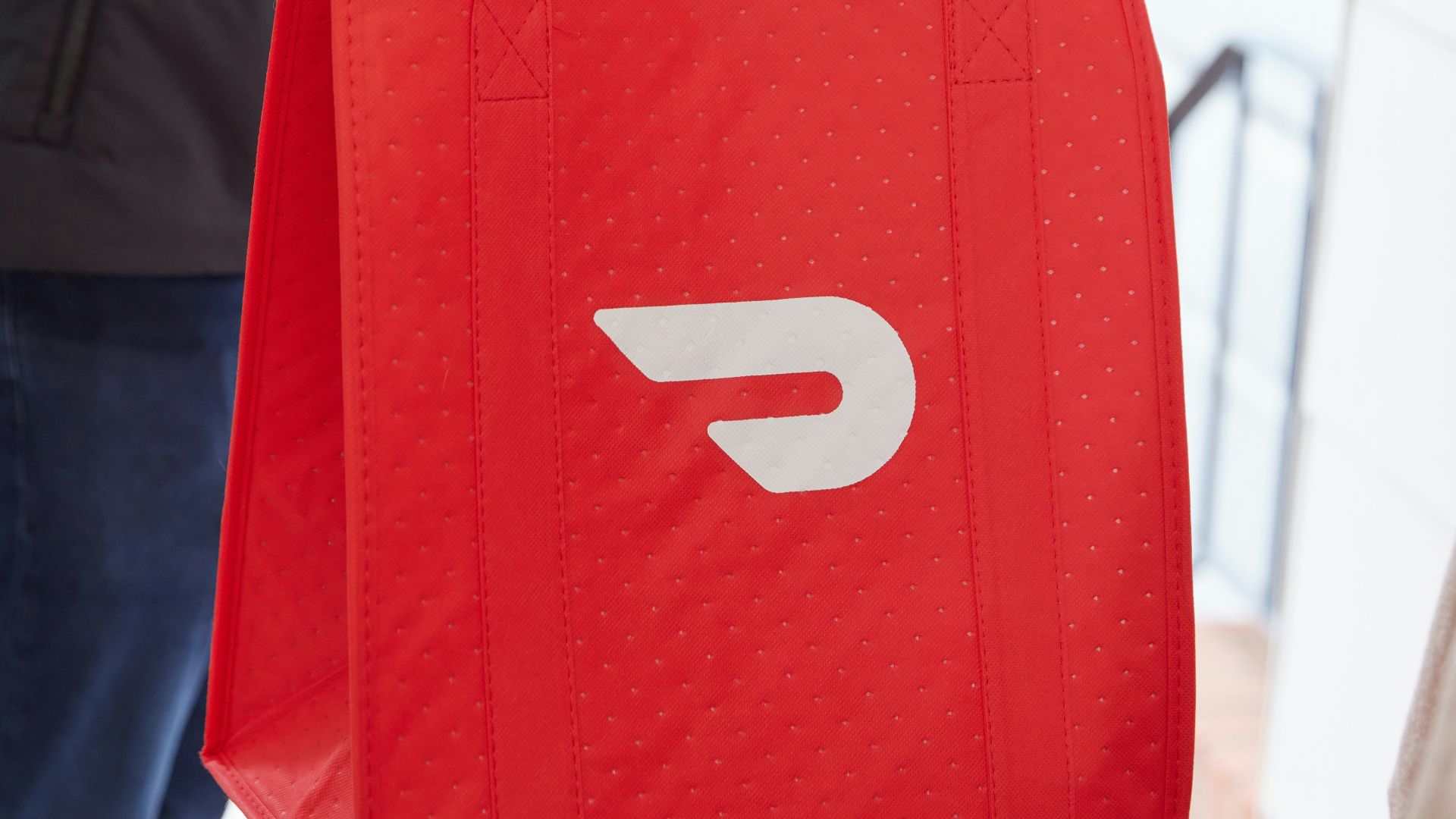 a person holding a red bag with the letter D on it