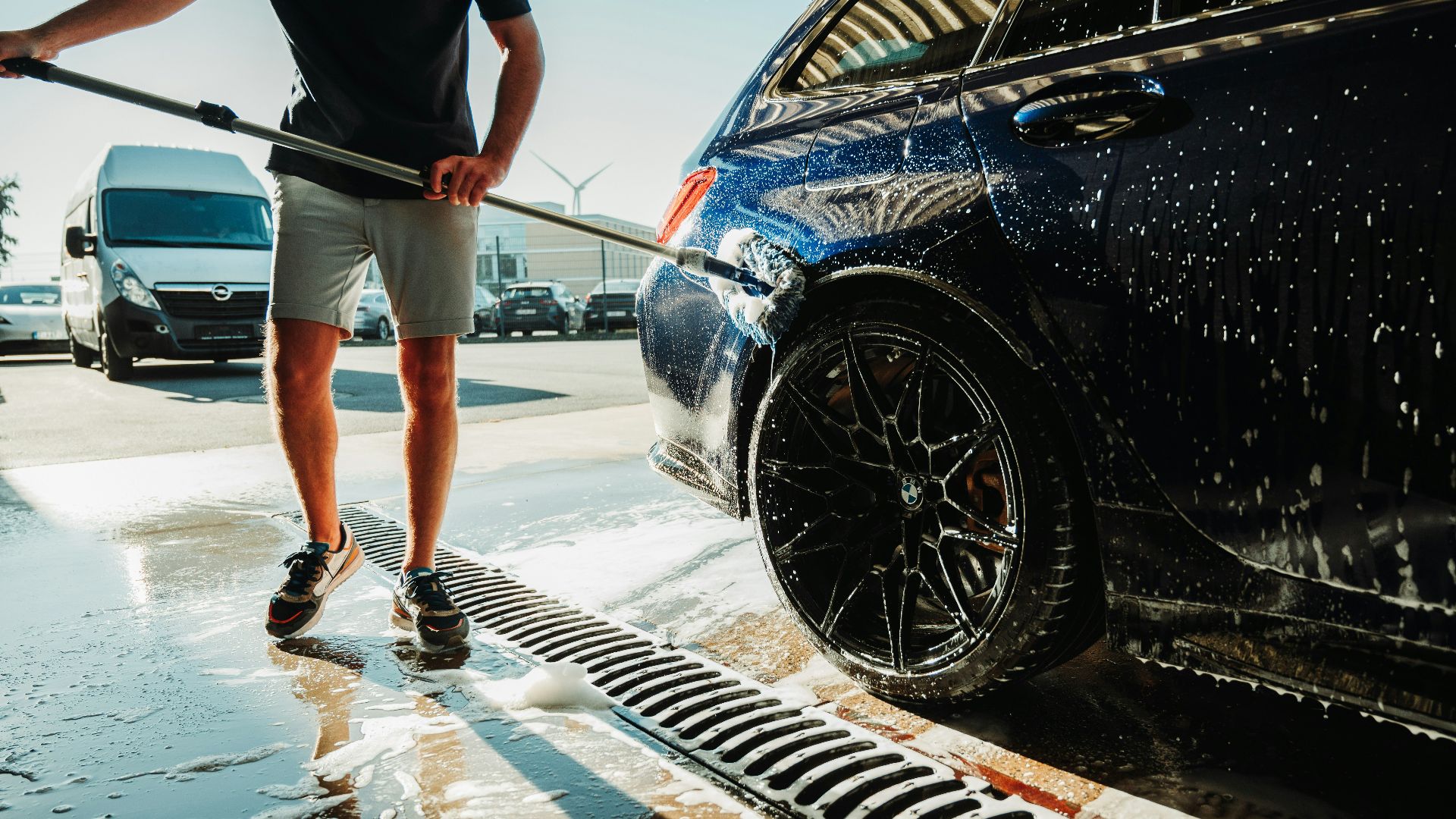 a man is washing a car with a hose