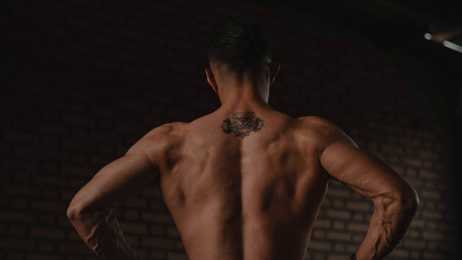 A man standing in a dark room with his back to the camera