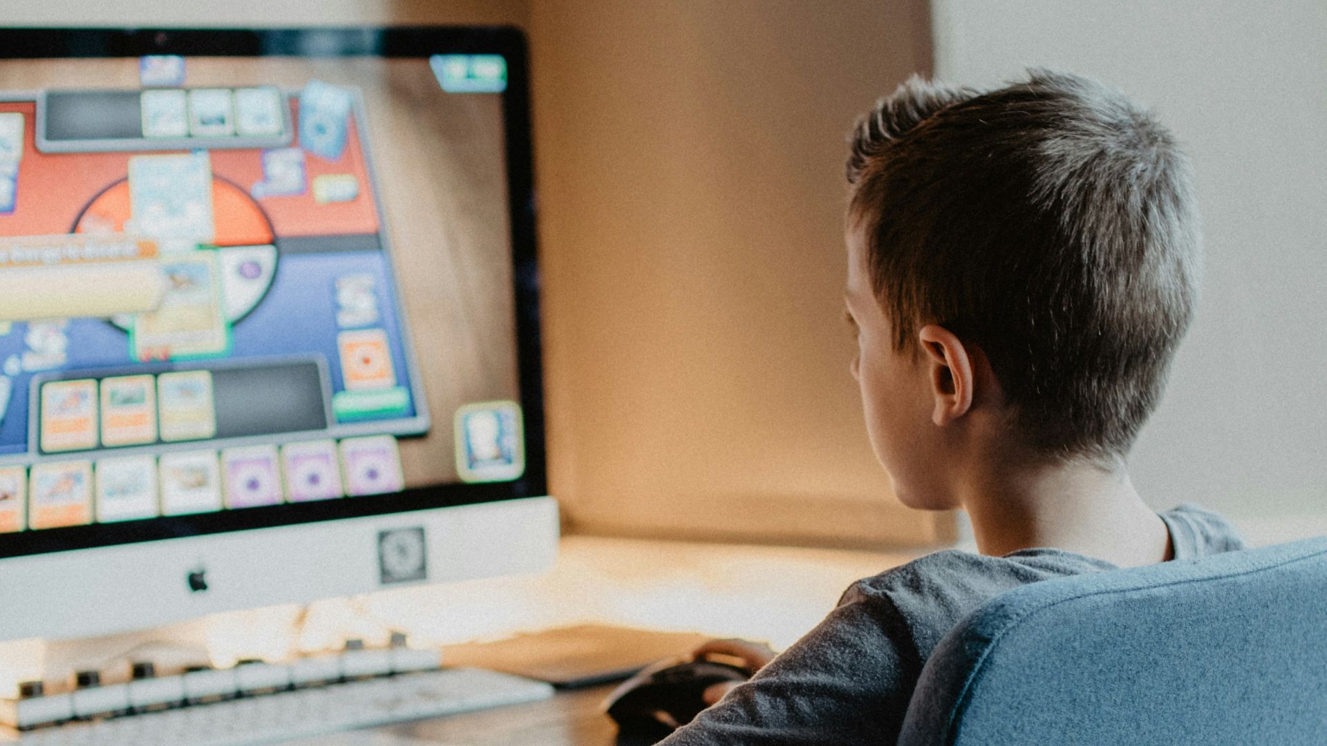 boy in black long sleeve shirt sitting on blue chair
