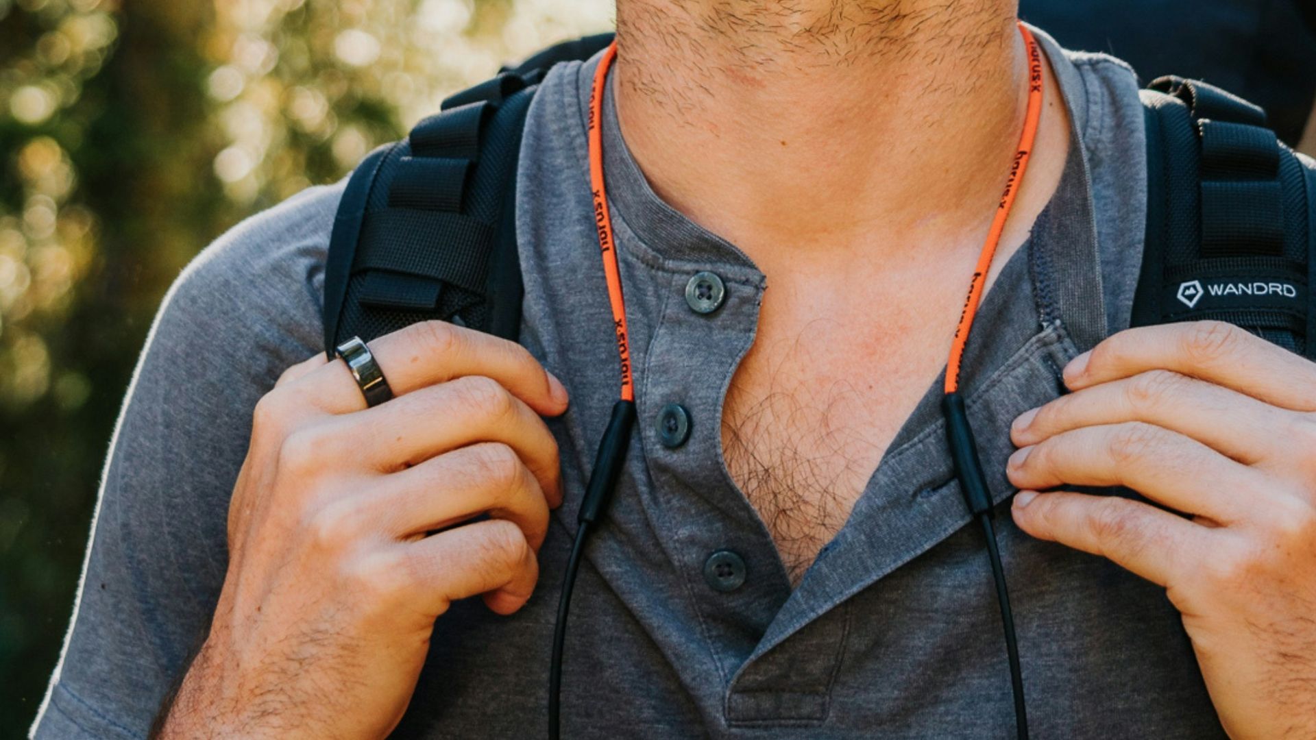 Man with backpack looking up in forest