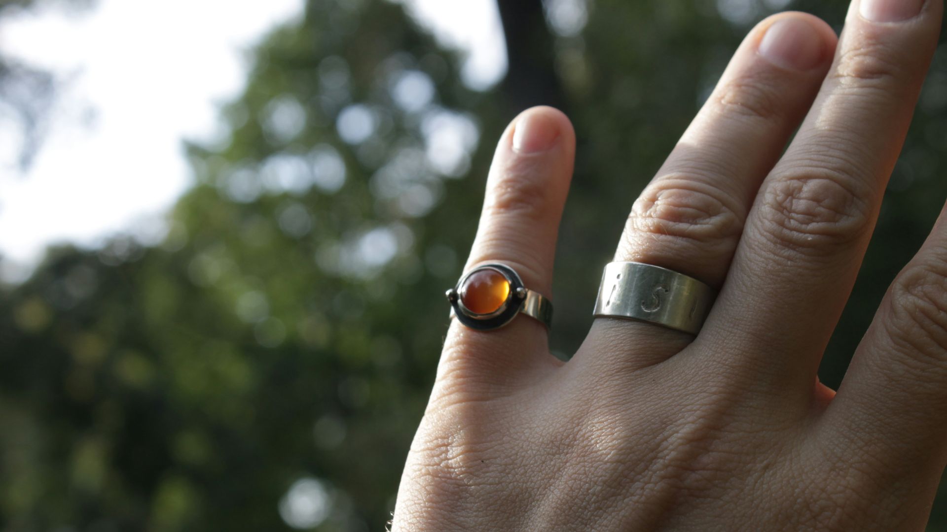 a person's hand with a ring on it