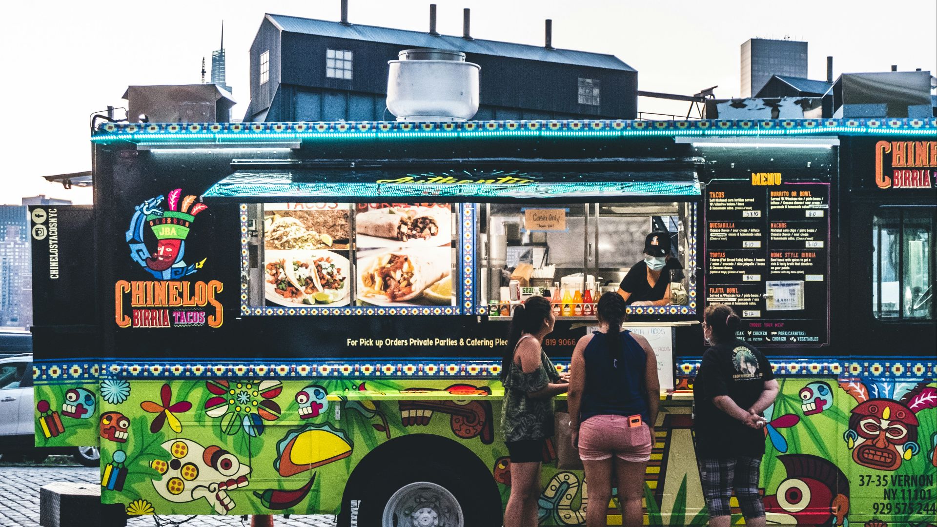 a group of people standing in front of a food truck