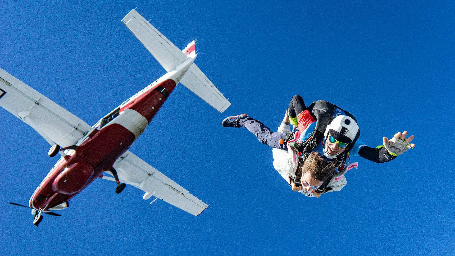 white and red airplane in mid air during daytime