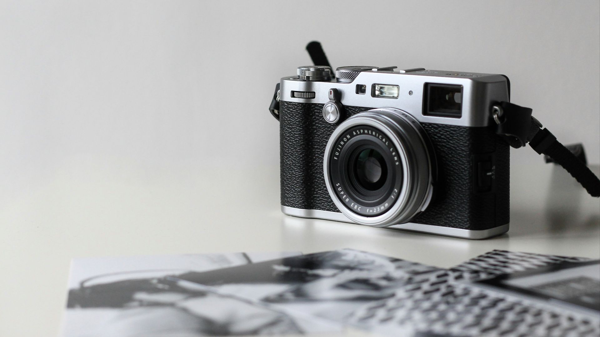 black and gray film camera near printed photos