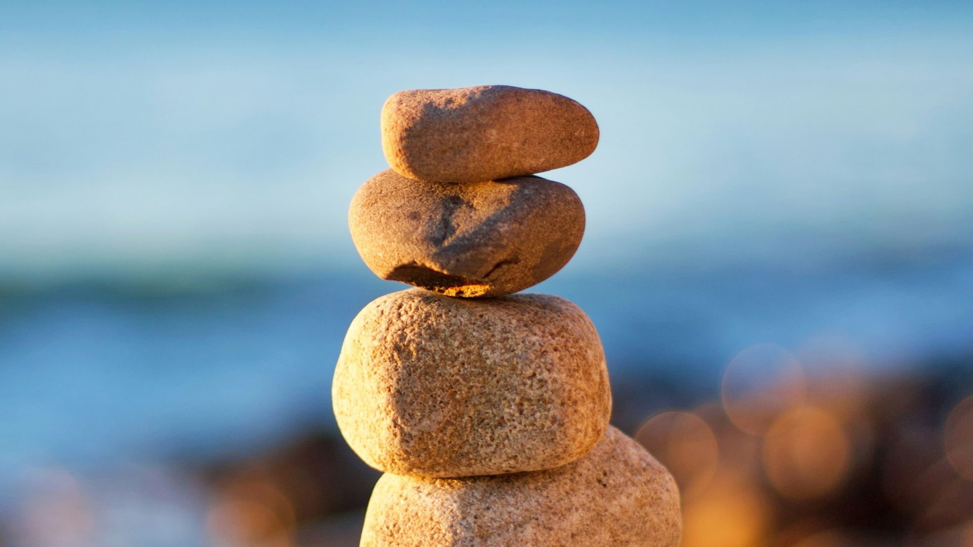 stack of stones near body of water during daytime