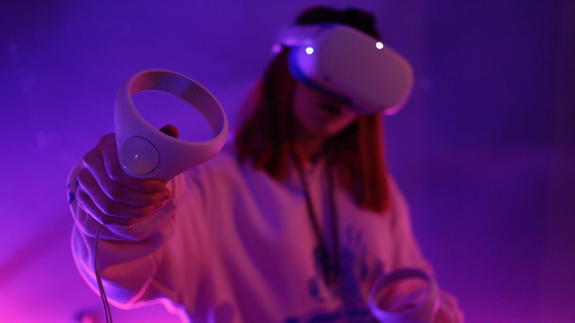 a woman holding a video game controller in her hand