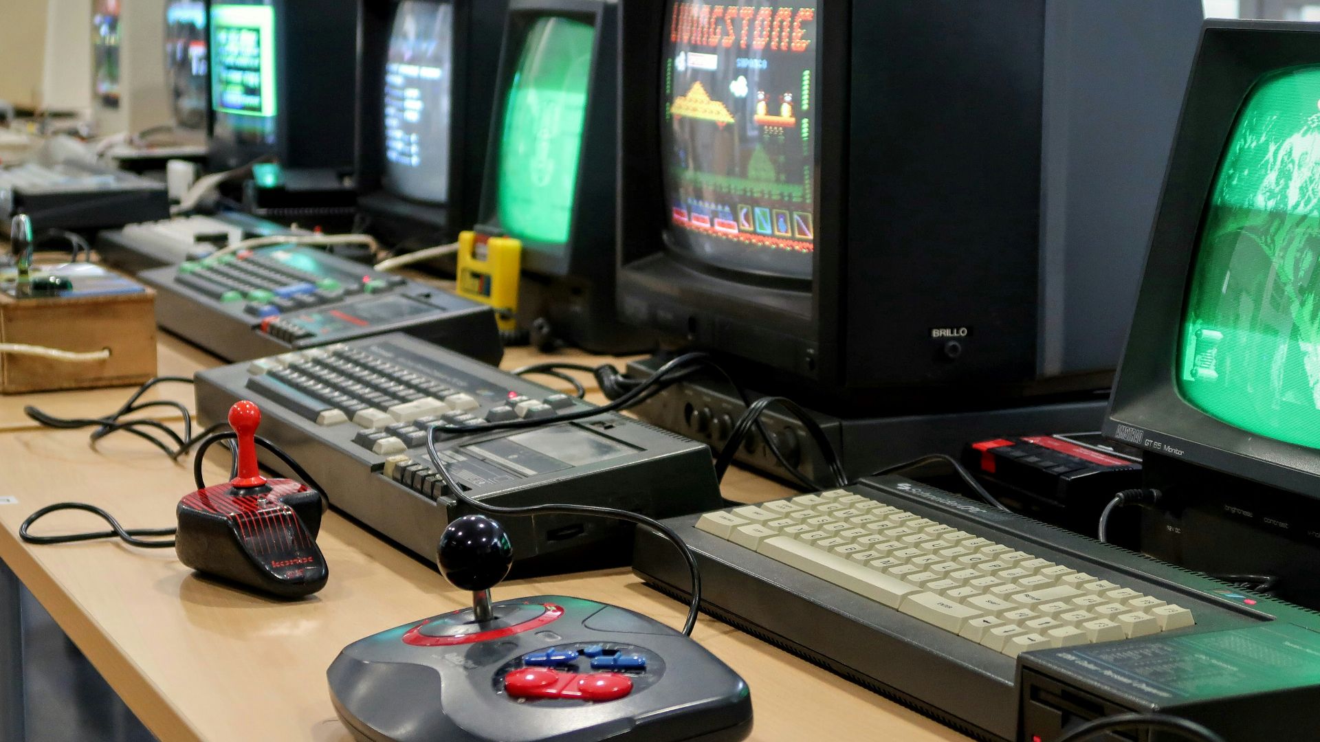 a row of computer monitors sitting on top of a desk