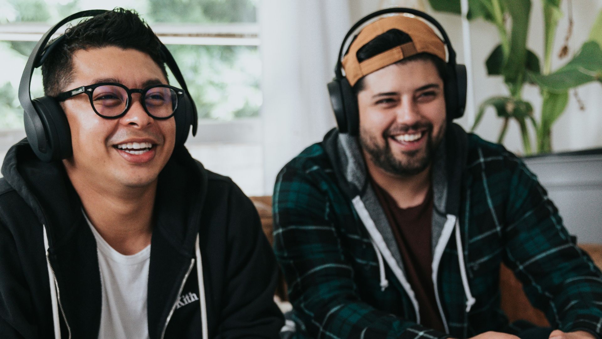 a couple of men sitting at a table with game controllers