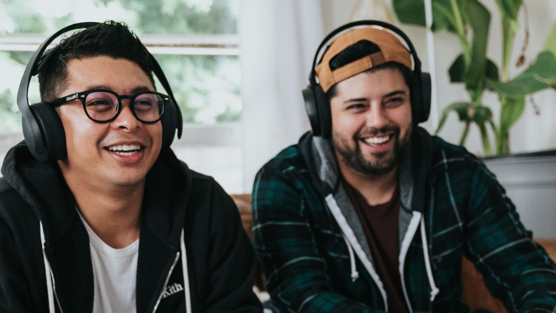 a couple of men sitting at a table with game controllers