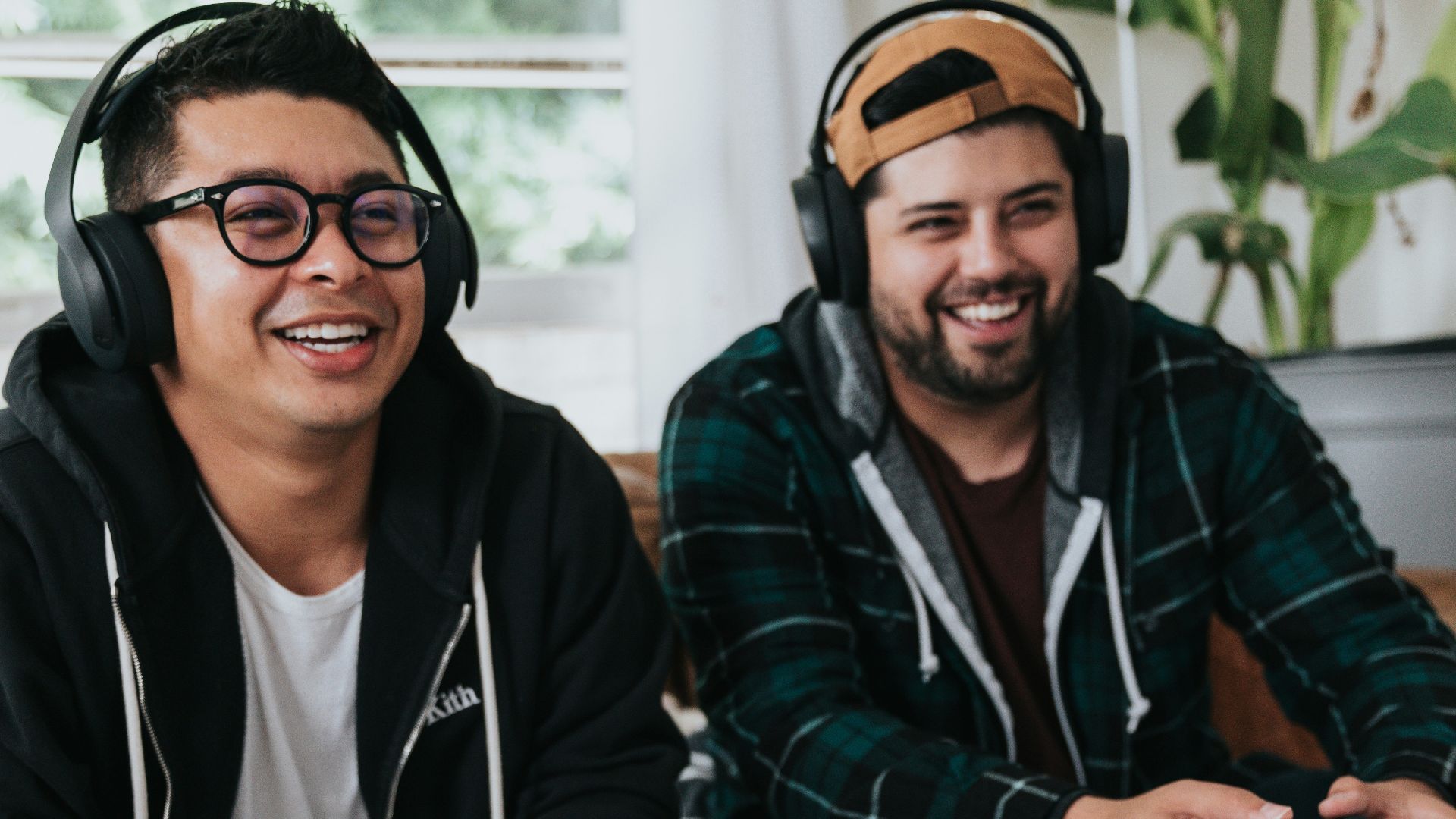a couple of men sitting at a table with game controllers