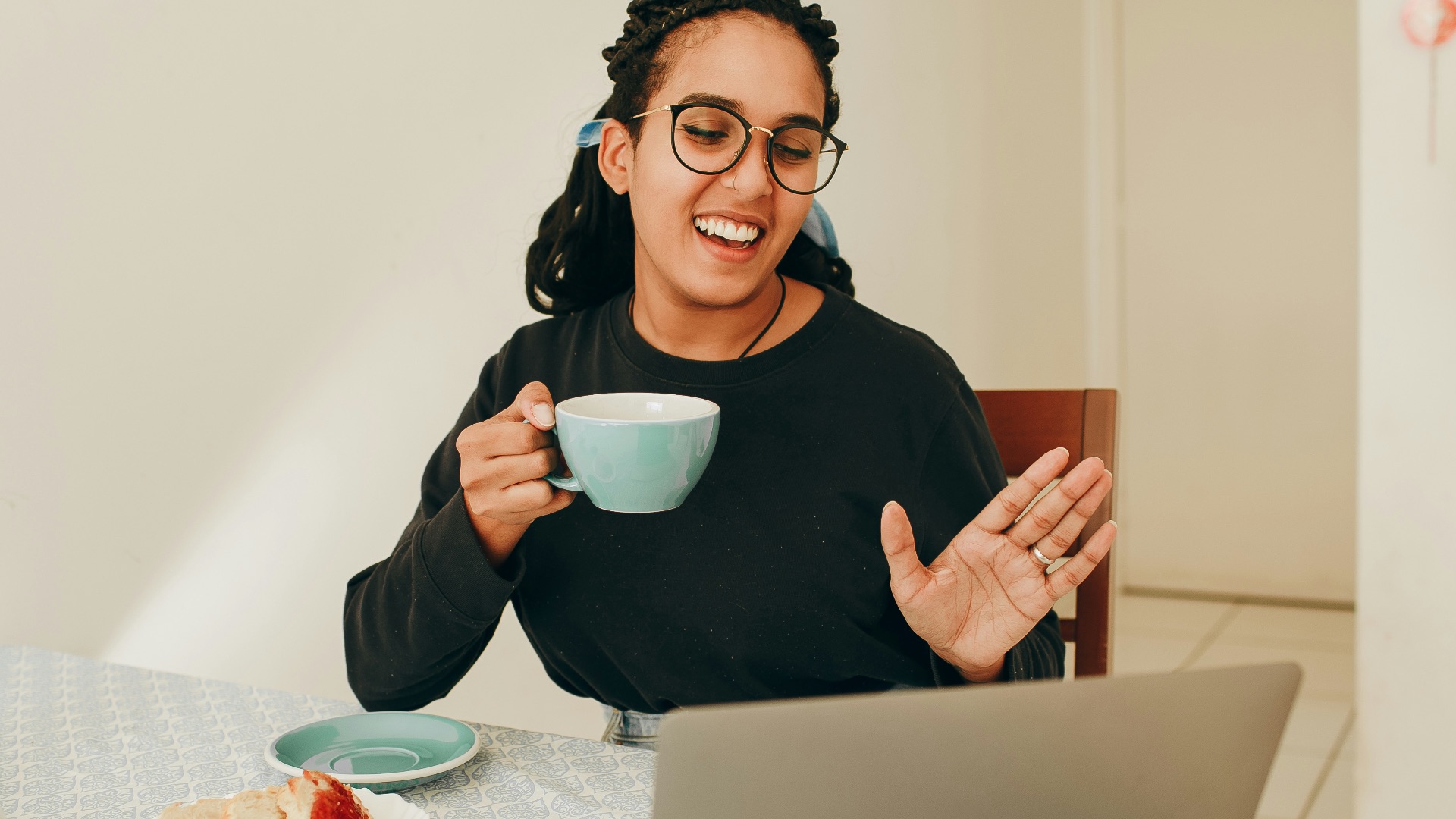 woman in black long sleeve shirt holding white ceramic mug