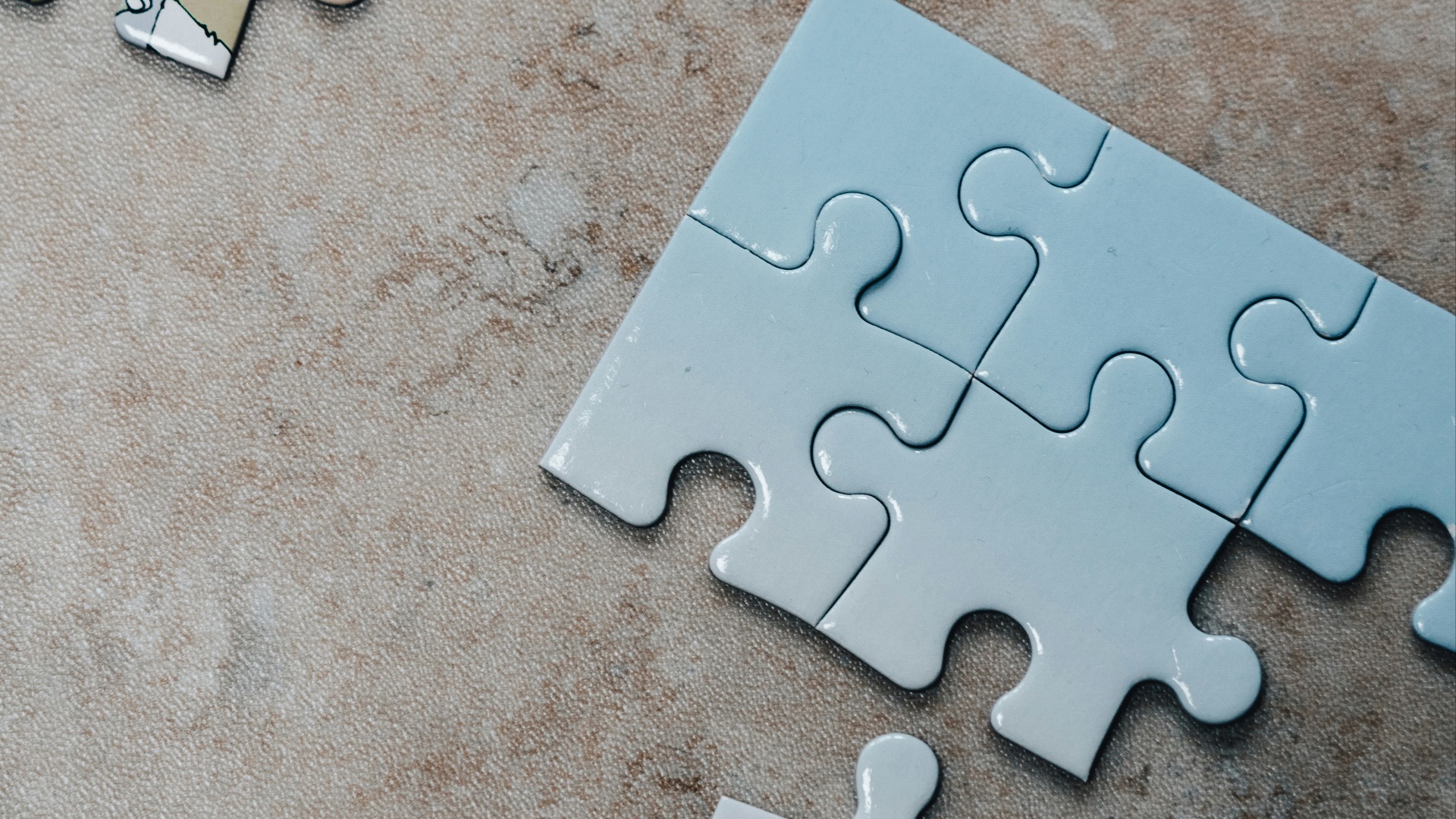 white jigsaw puzzle pieces on brown marble table